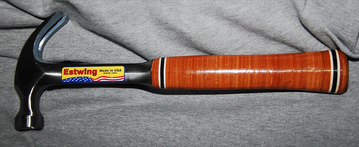 An Estwing steel curved-claw hammer with a stacked leather grip on a grey cloth