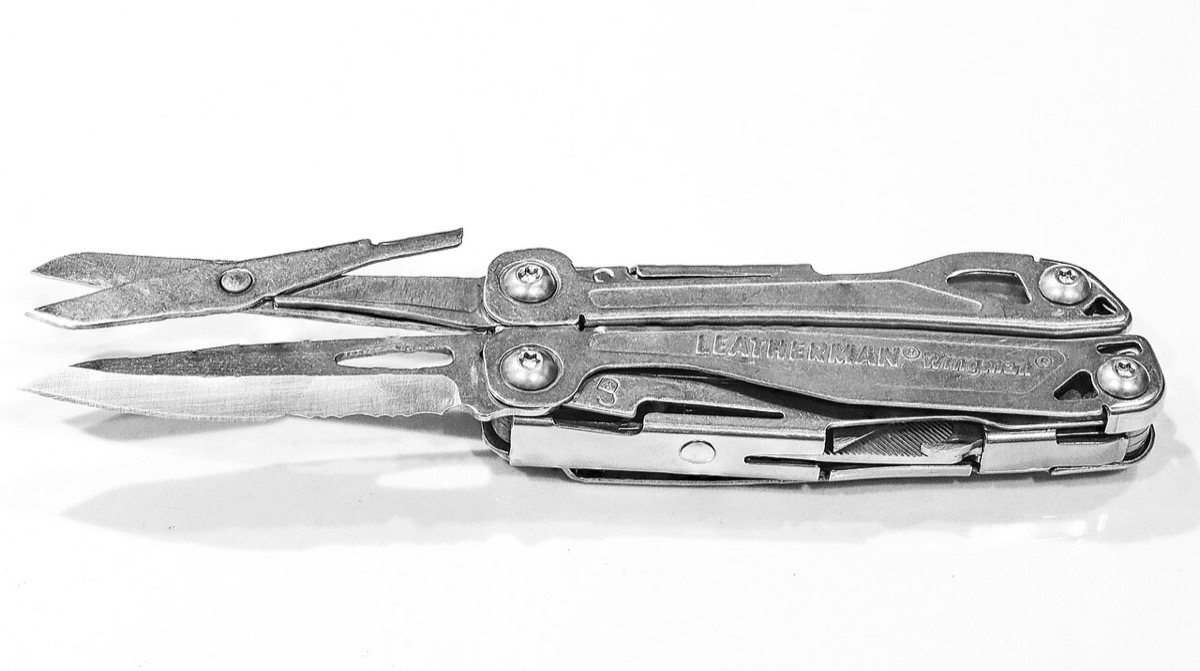 A Leatherman Wingman multi-tool, closed, with its scissors and knife folded out, in black and white